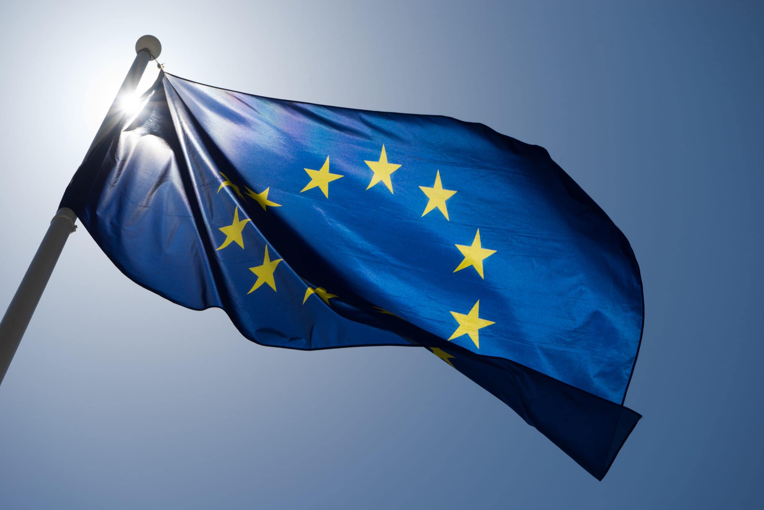 Series of images of the EU flag flying in the wind, backlight and blue sky