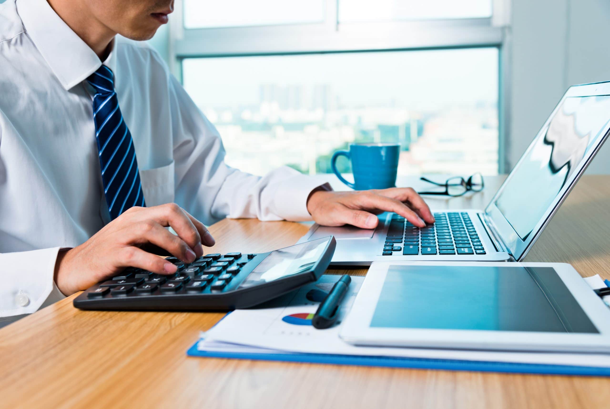 Businessman working with digital tablet and laptop in office room