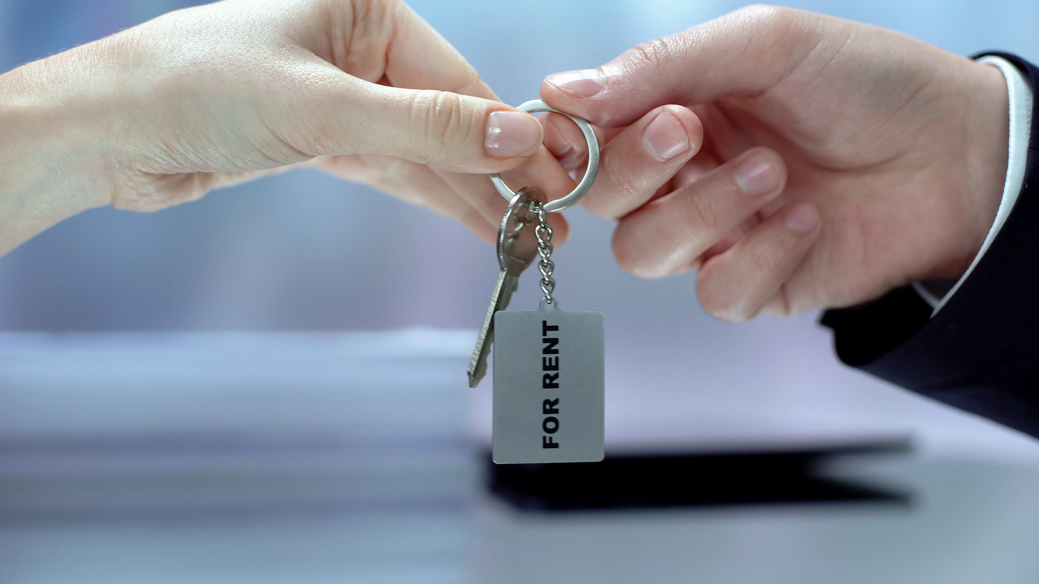 Woman taking keychain from hand, accommodation for rent, real estate business