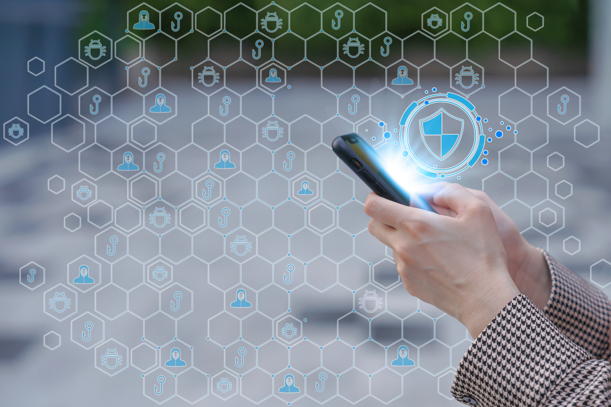 Business woman hand holding smartphone with virtual of network security shield to protected from cyber attacks. The concept of cybersecurity the Internet.