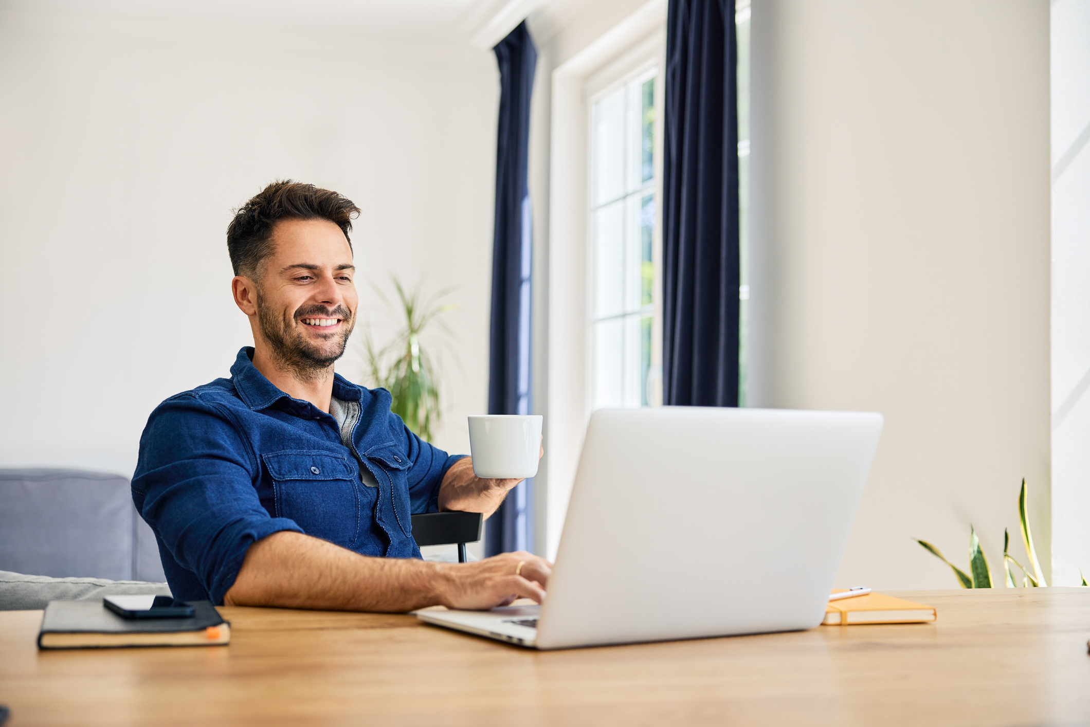 Relaxed man working on laptop at home working from home